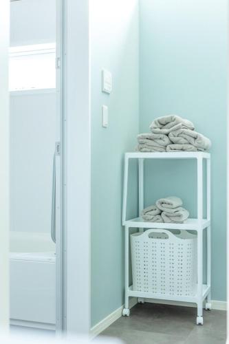 a room with a white shelf with towels on it at RD House in Katsuyama