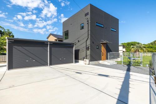 a house with a metal garage door at RD House in Katsuyama