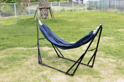 a blue hammock sitting in the grass in a yard at RD House in Katsuyama