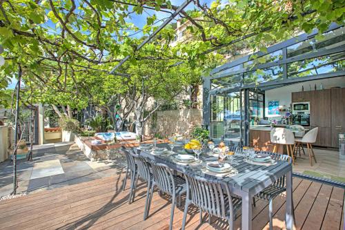 une terrasse en bois avec une table et des chaises. dans l'établissement Petit Paradis - Sea View, à Beaulieu-sur-Mer