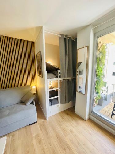 un salon avec un canapé et une fenêtre dans l'établissement Studio avec piscine face à la mer, à Biarritz