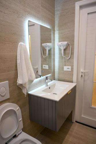 a bathroom with a sink and a mirror and a toilet at Swiss Lux apartments in Durrës