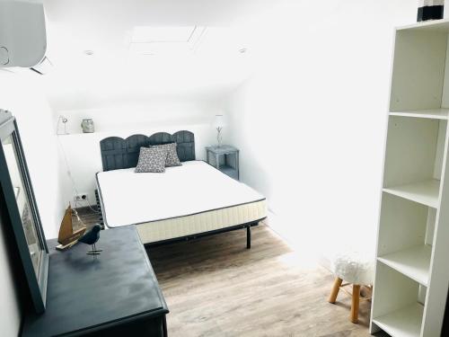 - une chambre avec un lit blanc dans une pièce avec des étagères dans l'établissement Maison de vacances à Oléron, à Saint-Denis-dʼOléron