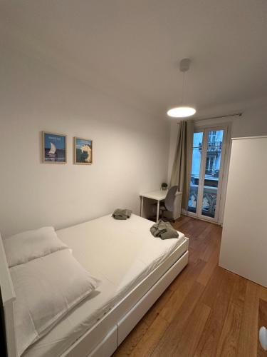 une chambre avec un lit blanc et un bureau dans l'établissement 3 bedroom Appartement City Center, à Nice