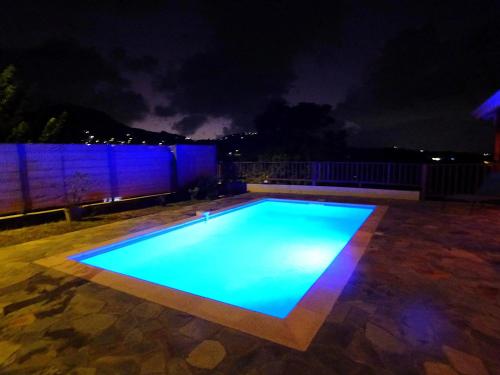 a swimming pool at night with blue lights at Villa avec piscine privée au Vauclin in Le Vauclin