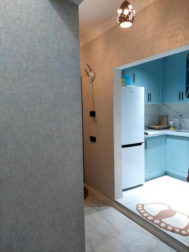 a kitchen with blue cabinets and a white refrigerator at Sumqayıt Abşeron City yaşayış kompleksi in Sumqayyt