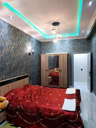 a bedroom with a bed with a red comforter at Sumqayıt Abşeron City yaşayış kompleksi in Sumqayyt