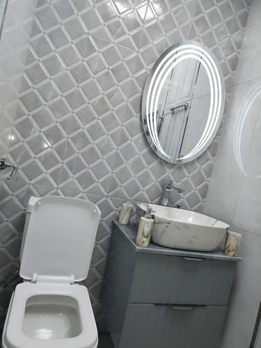 a bathroom with a white toilet and a mirror at Sumqayıt Abşeron City yaşayış kompleksi in Sumqayyt
