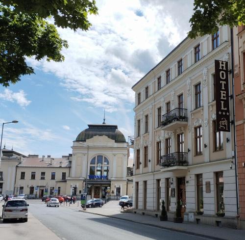 a building on a city street with cars parked at Hotel Gal in Tarnów