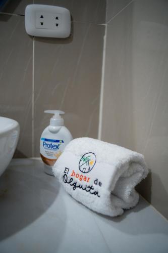 a towel on a bathroom counter with a bottle of soap at El Hogar de Olguita - Departamento Balcón in Tarapoto
