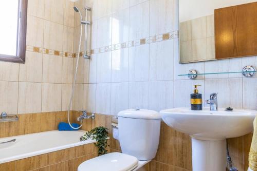 une salle de bain avec toilettes, lavabo et miroir dans l'établissement Villa Elissa by Villa Plus, à Pólis Chrysochoús