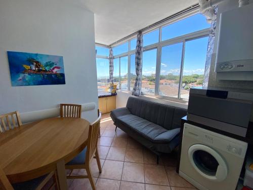 a living room with a couch and a dining room table at Casa Blu di Pomposa Vista Mare in Lido di Pomposa