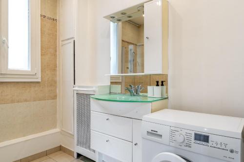 une salle de bain avec un lavabo et une machine à laver dans l'établissement Elegant studio Saint-Dominique, à Paris