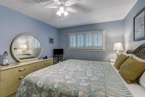 a bedroom with a large bed and a mirror at Top floor Oceanfront condo that has spectacular ocean views and sunrises. This condo sleeps 6. in Fernandina Beach