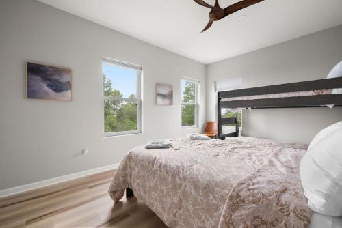 a white bedroom with a bed and two windows at Modern Escape w Mountain Views Fire Pit & Swing in Martinsburg