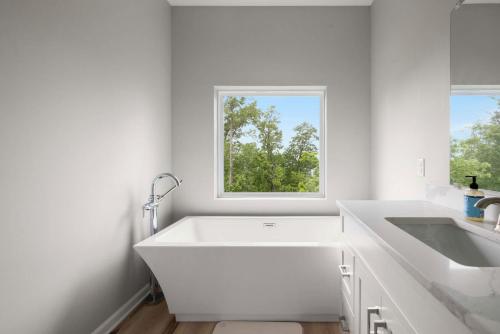 a white bathroom with a sink and a window at Modern Escape w Mountain Views Fire Pit & Swing in Martinsburg