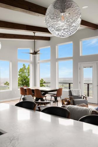 a dining room with a table and chairs and windows at Modern Escape w Mountain Views Fire Pit & Swing in Martinsburg