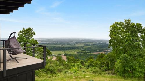 a balcony with an umbrella on top of a house at Modern Escape w Mountain Views Fire Pit & Swing in Martinsburg