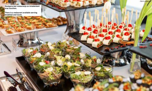 Un buffet lleno de aperitivos y postres en exhibición. en Silver Rooms - Poznań - by Kramm Apartments, en Poznan