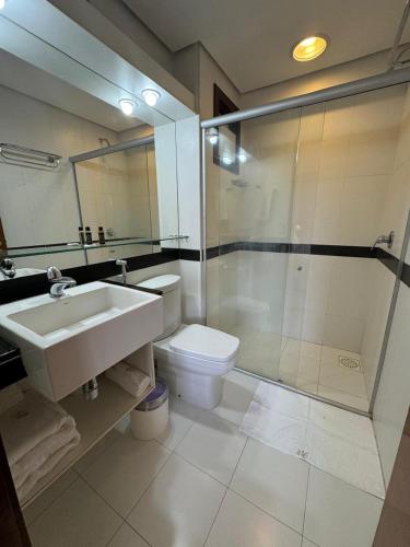 a bathroom with a toilet and a sink and a shower at Kariri Beach Residence in Caucaia