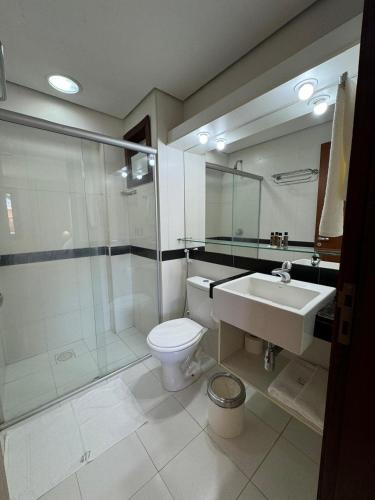 a bathroom with a toilet and a shower and a sink at Kariri Beach Residence in Caucaia