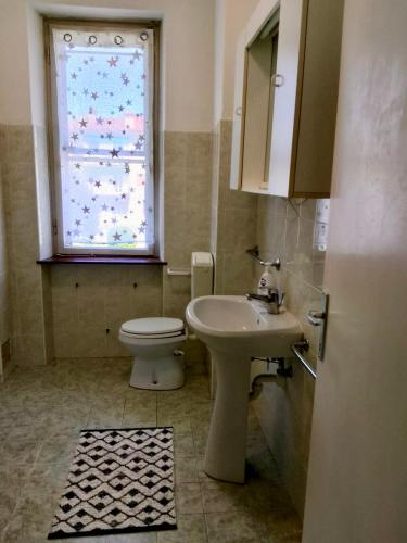 a bathroom with a sink and a toilet and a window at Appartamento luna, vicino centro storico in Spilimbergo