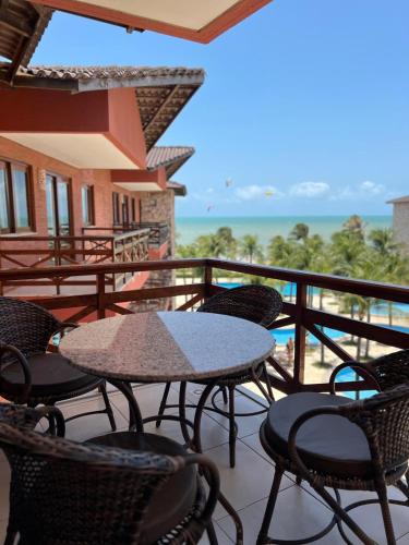 a patio with tables and chairs on a balcony at Kariri Beach Residence in Caucaia