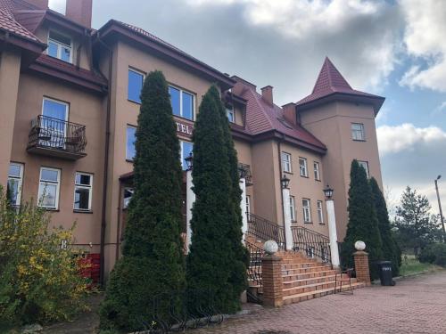 a large house with trees in front of it at Forest Castle in Maurzyze