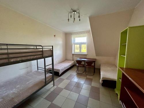 a room with two bunk beds and a table at Forest Castle in Maurzyze