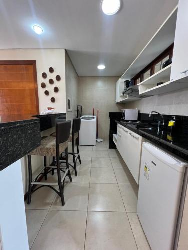 a kitchen with a table and some chairs in it at Kariri Beach Residence in Caucaia