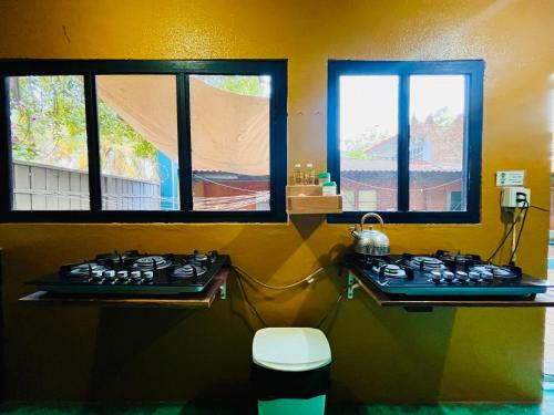 a kitchen with a stove and two windows at Wasi la Punta 5 Starlink 2min walk to the beach in Brisas de Zicatela