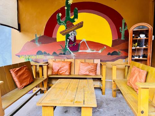 a room with benches and a painting on the wall at Wasi la Punta 5 Starlink 2min walk to the beach in Brisas de Zicatela