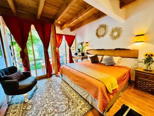 a bedroom with a bed and a chair at Encino House Hotel Boutique in Valle de Bravo