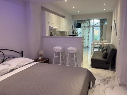 a bedroom with a bed and a couch and a kitchen at Aggelikas apartments 2 in Paleokastritsa