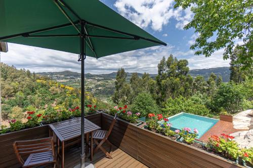 a patio with a table and an umbrella at ALDEIA DA MARGARIDA in Tarouquela