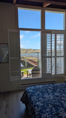 a bedroom with a large window with a view of the ocean at Tomales Bay Lodge and Marina Inc in Inverness