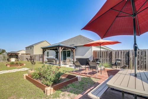 a patio with a table and a red umbrella at 1 Mi to Shopping District Chic Springfield Home in Springfield
