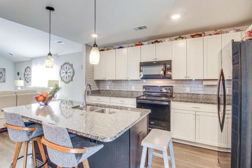 a kitchen with white cabinets and a island with bar stools at 1 Mi to Shopping District Chic Springfield Home in Springfield