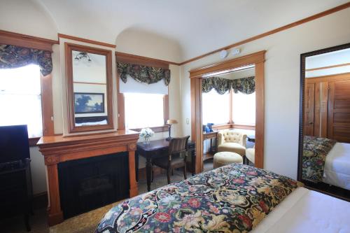 a bedroom with a bed and a desk and a room with a bed at The Charles Pacific Grove in Pacific Grove