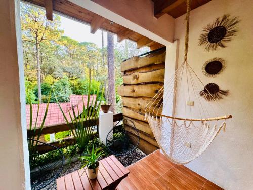 a porch with a hammock hanging from a wall at Encino House Hotel Boutique in Valle de Bravo