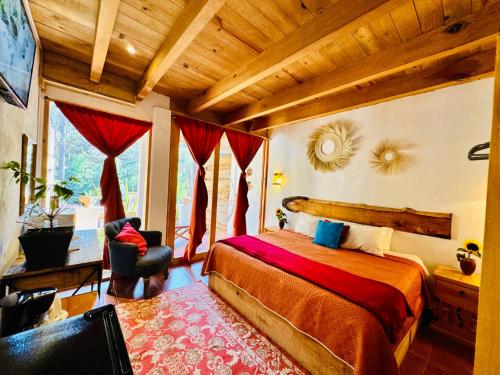 a bedroom with a bed and a chair in a room at Encino House Hotel Boutique in Valle de Bravo