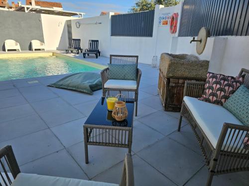 a patio with a table and chairs next to a pool at Russa AL in Lentiscais