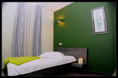 a green bedroom with a bed and a fireplace at Hotel Diafan in Baia Mare