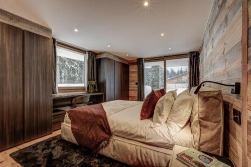 une chambre avec un lit, un bureau et des fenêtres dans l'établissement Chalet Freya, à Chamonix-Mont-Blanc