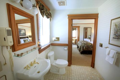 a bathroom with a toilet and a sink and a mirror at The Charles Pacific Grove in Pacific Grove