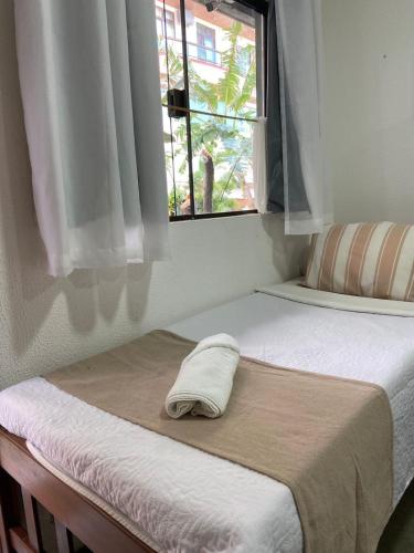 two beds in a room with a window at Pousada Cantinho de Minas Da Tânia in Cabo Frio