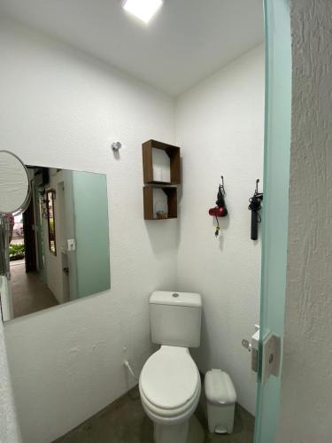 a bathroom with a toilet and a mirror at Pousada Cantinho de Minas Da Tânia in Cabo Frio