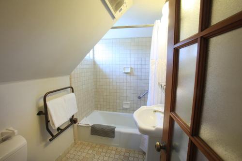 a bathroom with a sink and a tub and a toilet at The Charles Pacific Grove in Pacific Grove
