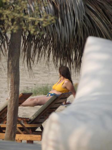 a woman sitting on a picnic table on the beach at Baja Canoas Hotel in Canoas De Punta Sal