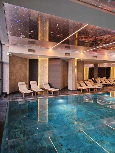 a hotel lobby with a pool and chairs at Marrilux apartments Residence Hill in Kopaonik